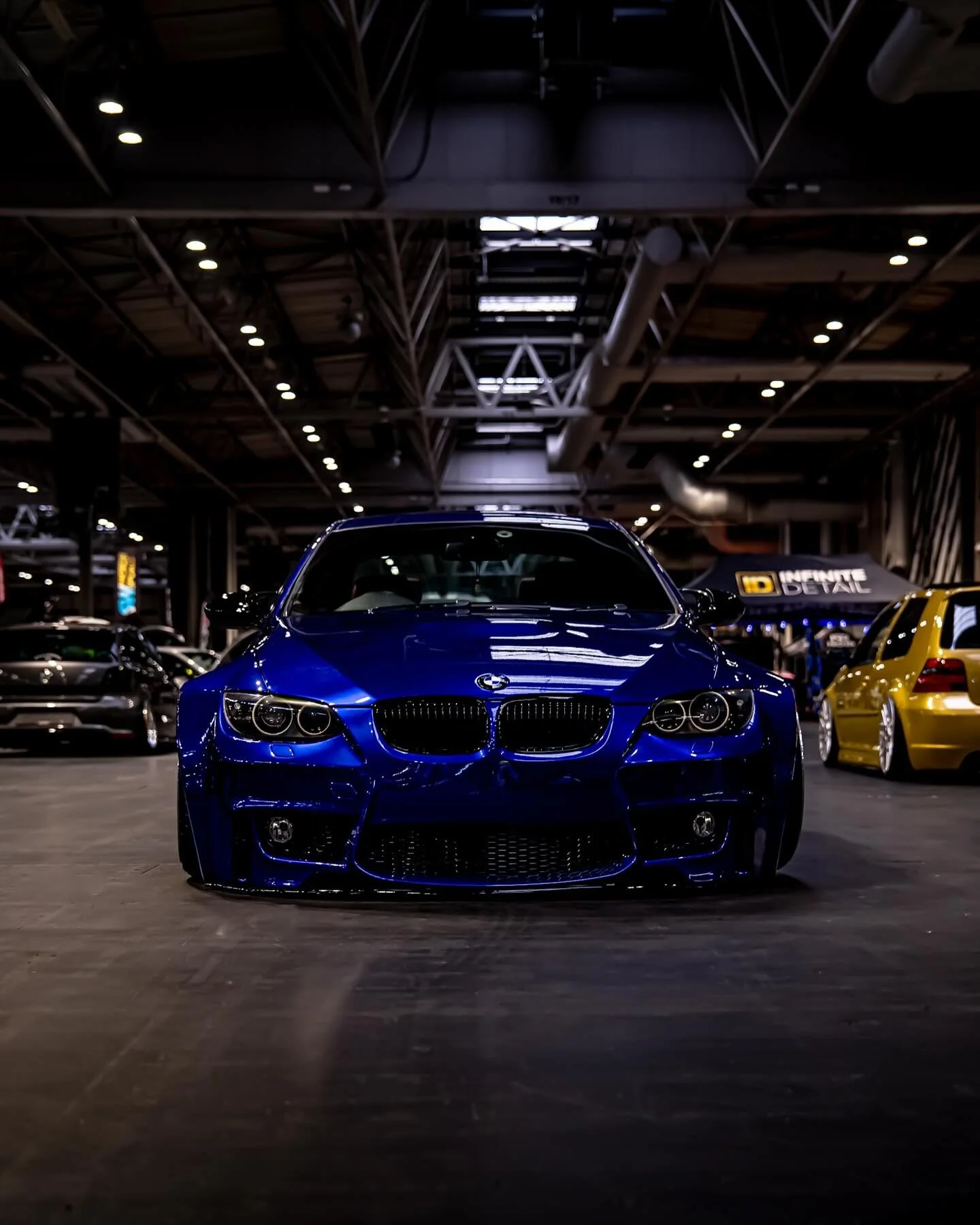 Blue BMW photographed at an indoor automotive event